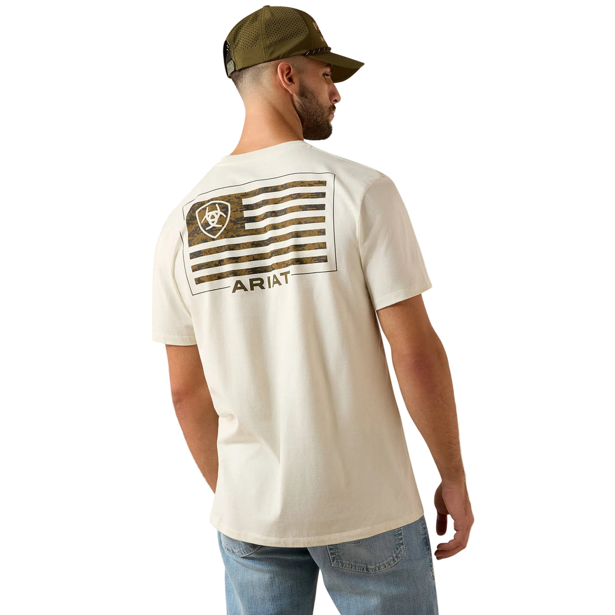 Man wearing a white t-shirt with a flag design and 'Ariat' branding on the back, standing against a beige background.