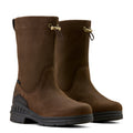 Pair of brown boots with black soles on a beige background