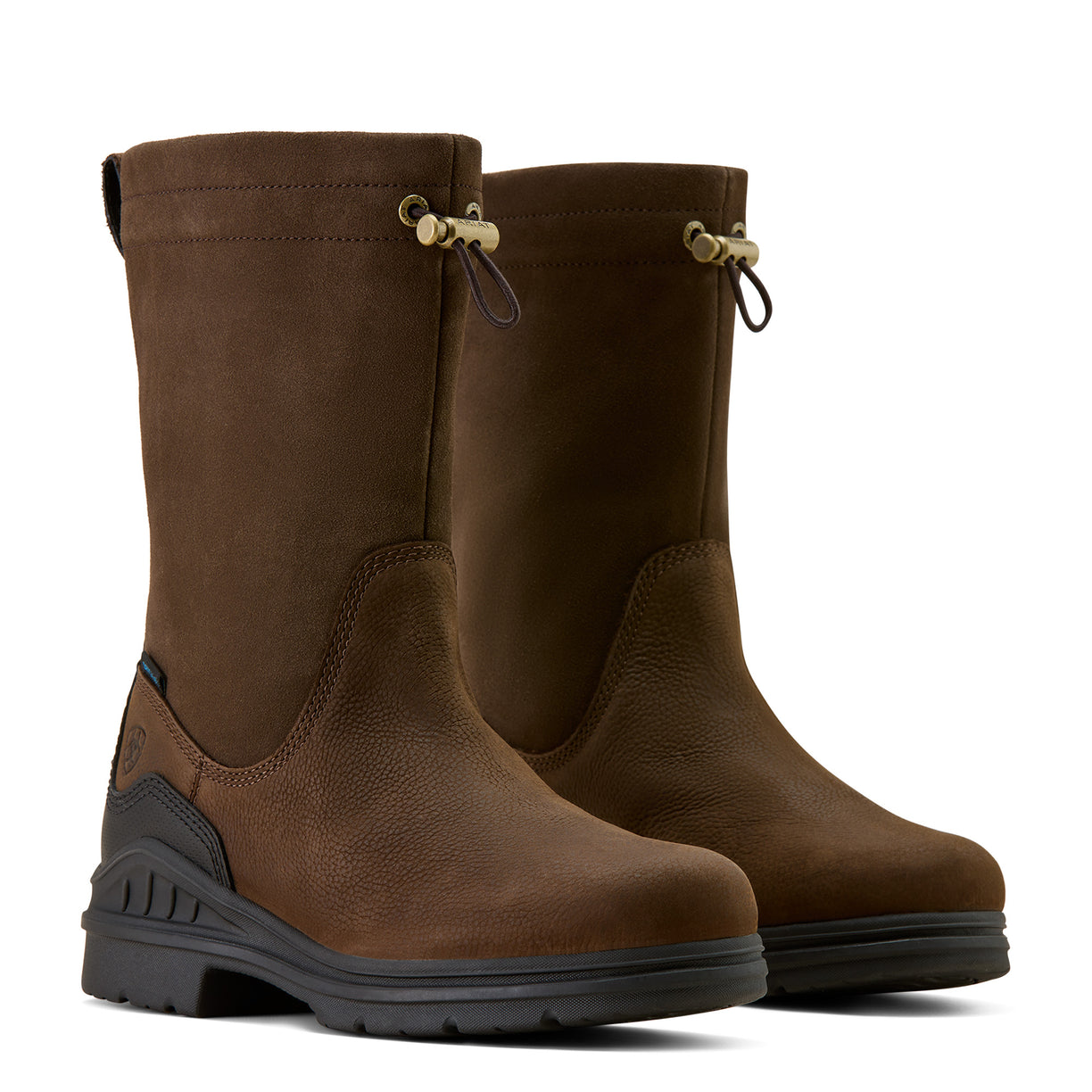Pair of brown boots with black soles on a beige background