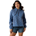 Woman wearing a blue patterned pullover with denim shorts on a white background