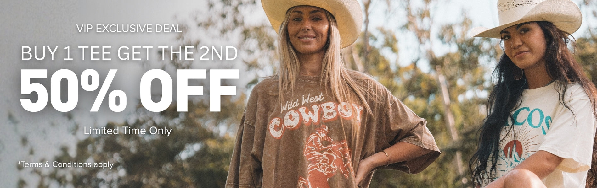 Two women wearing Ariat graphic tees outdoors