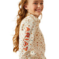 Girl wearing a patterned shirt with visible branding on a white background