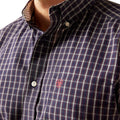 Close-up of a checkered shirt with a small logo on the chest.