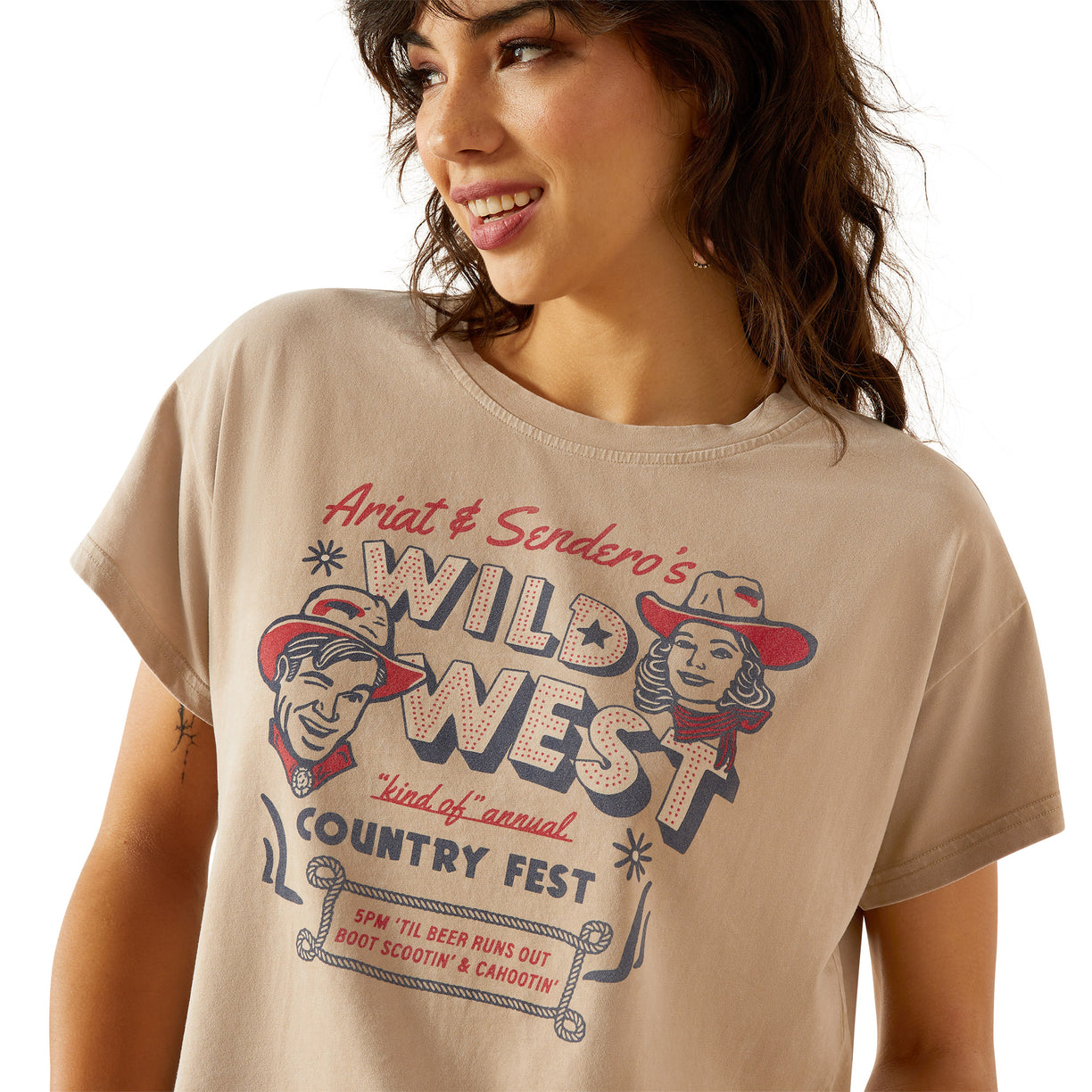 Woman wearing a beige t-shirt with 'Wild West Country Fest' graphic design.