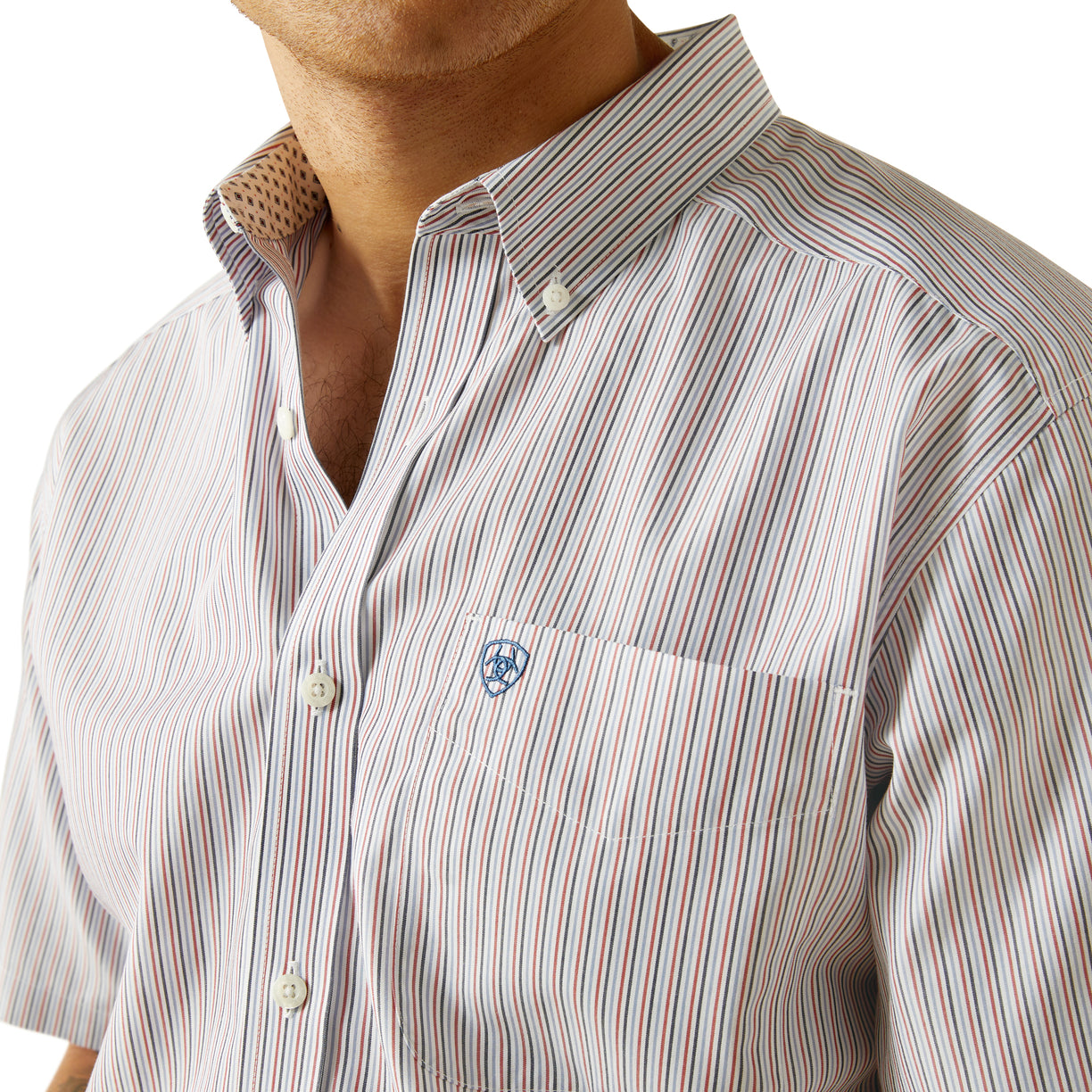 Close-up of a striped shirt with a visible brand logo on a white background