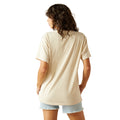 Woman wearing a beige t-shirt and light blue shorts on a white background