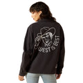 Person wearing a black sweatshirt with a graphic and text on the back, on a white background