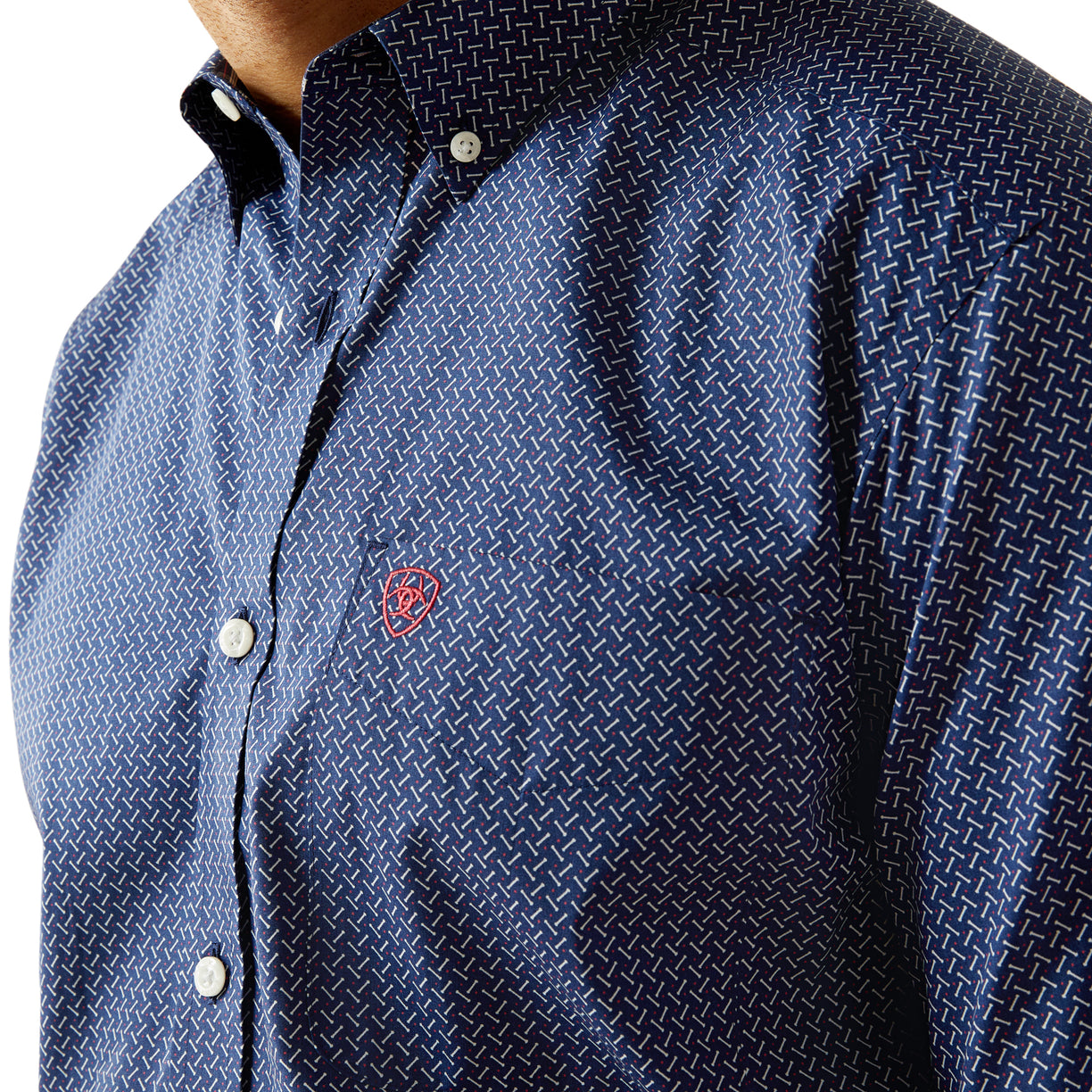 Close-up of a blue patterned shirt with a red logo on a white background