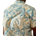 Beige shirt with blue tropical leaf pattern worn by a person