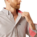 Man adjusting the collar of a checkered shirt with red inner lining