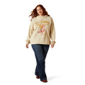 Woman wearing a beige hoodie with graphic design on a white background