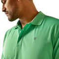 Close-up of a person wearing a green polo shirt with a brand logo.