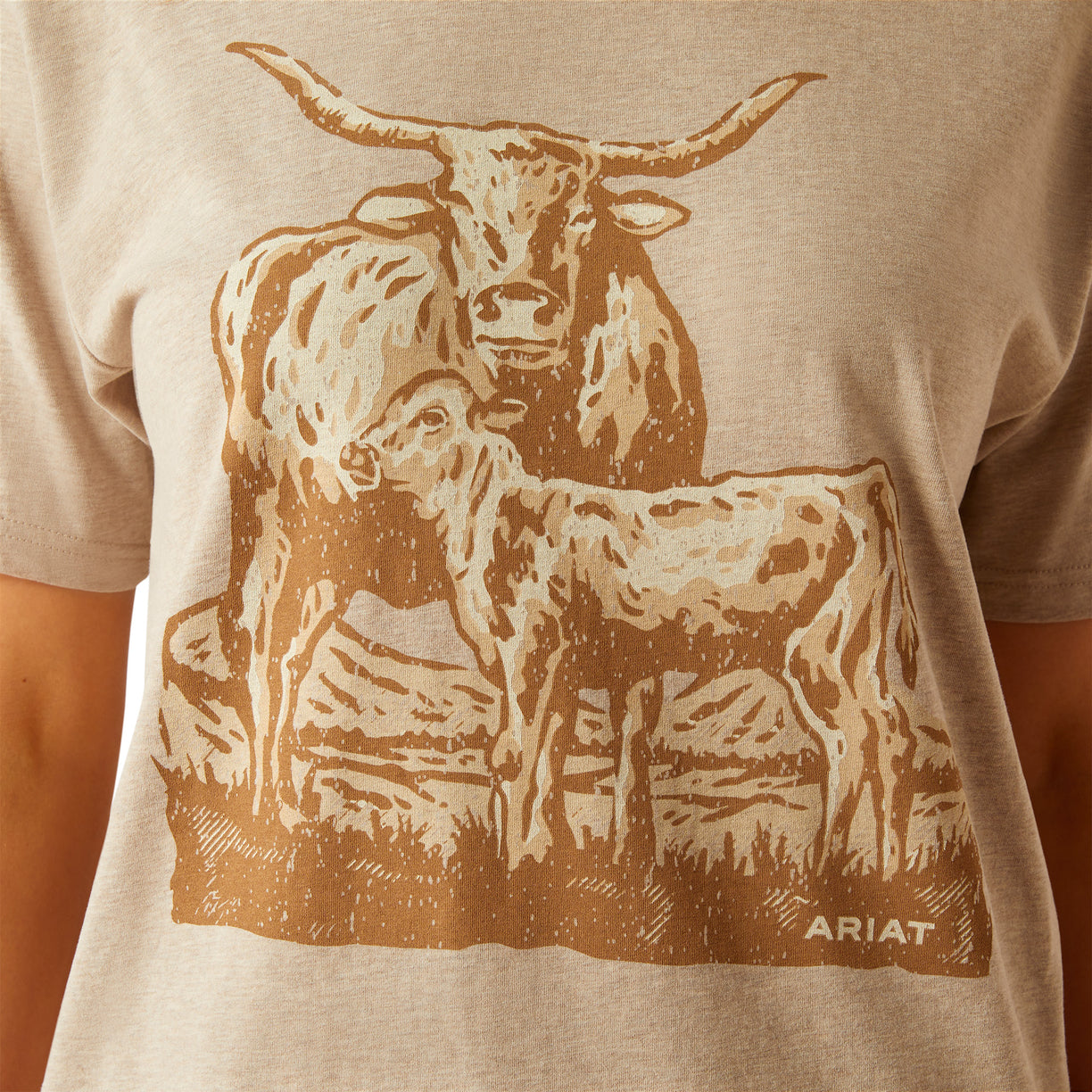 Beige t-shirt with a brown graphic of a cow and calf, featuring the Ariat logo.