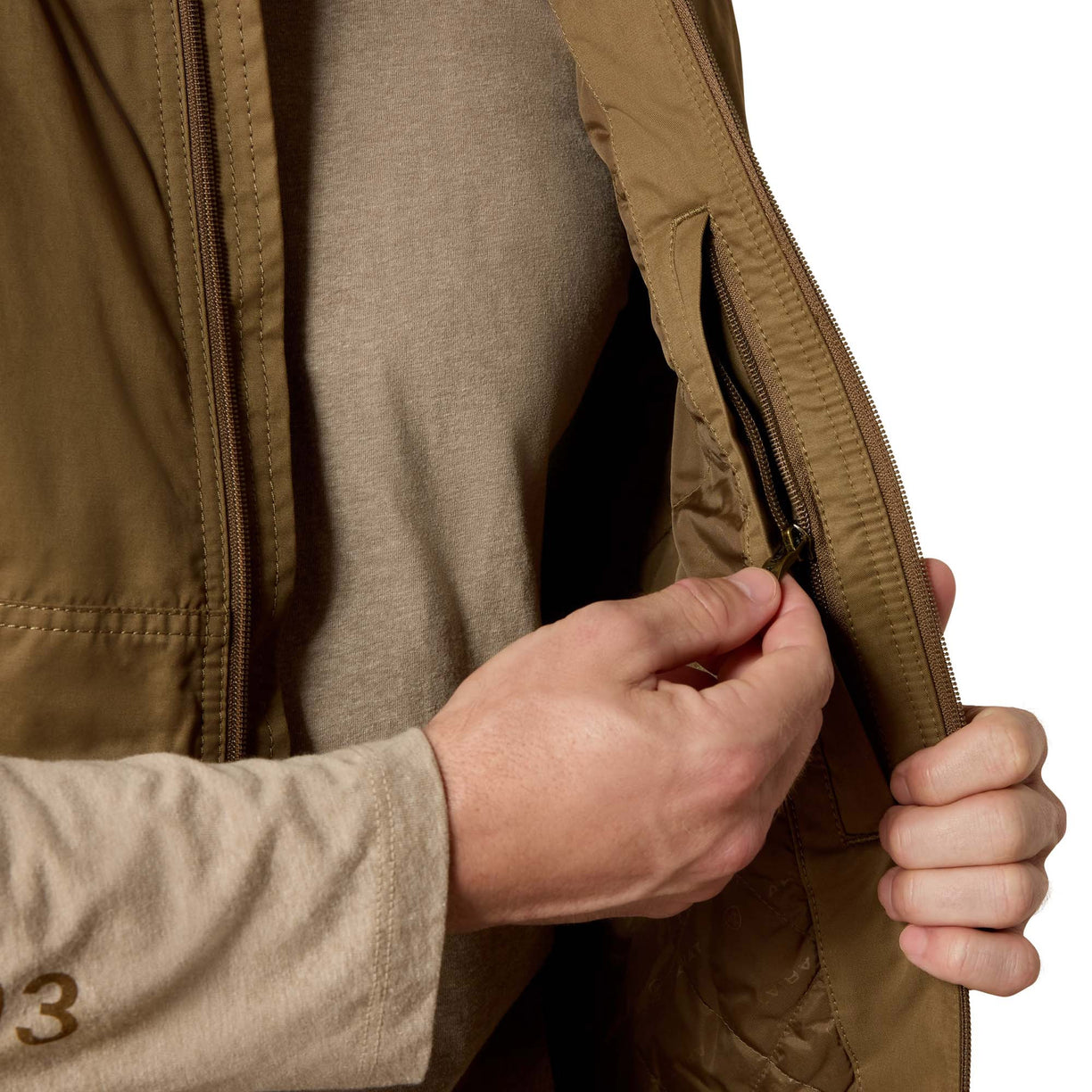 Close-up of a person wearing a beige jacket with a zipper, focusing on the hand and sleeve.